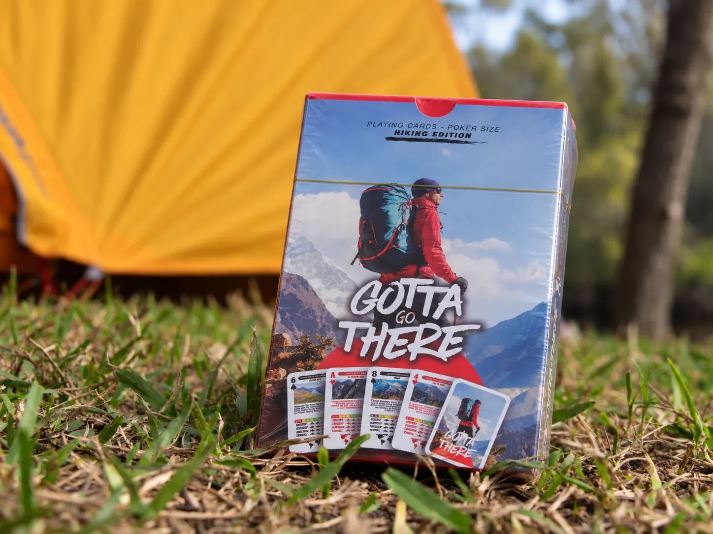 Gotta Go There Hiking Edition standing in the grass in front of an orange tent